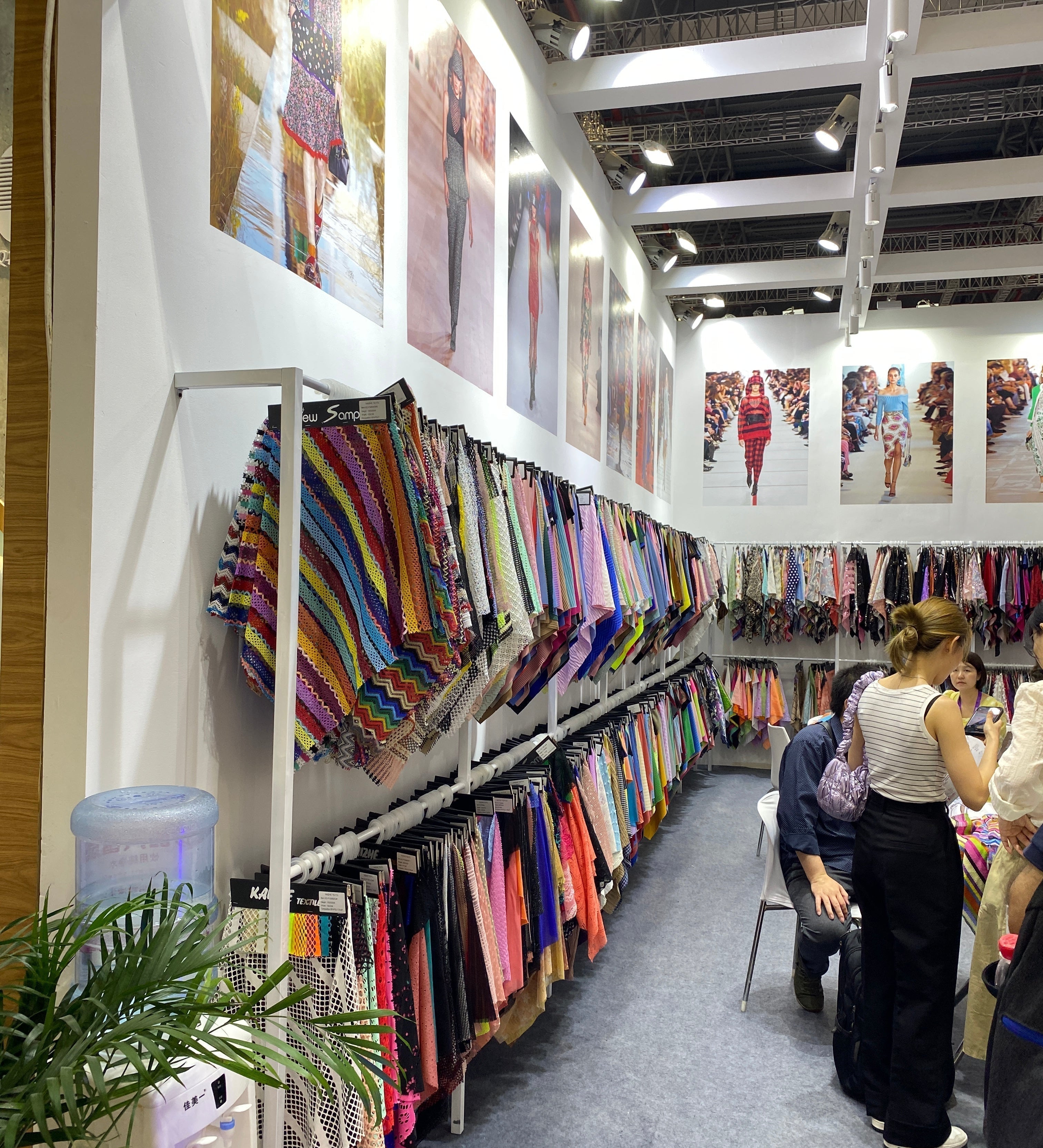 Ladies looking through a display of certified fabrics.