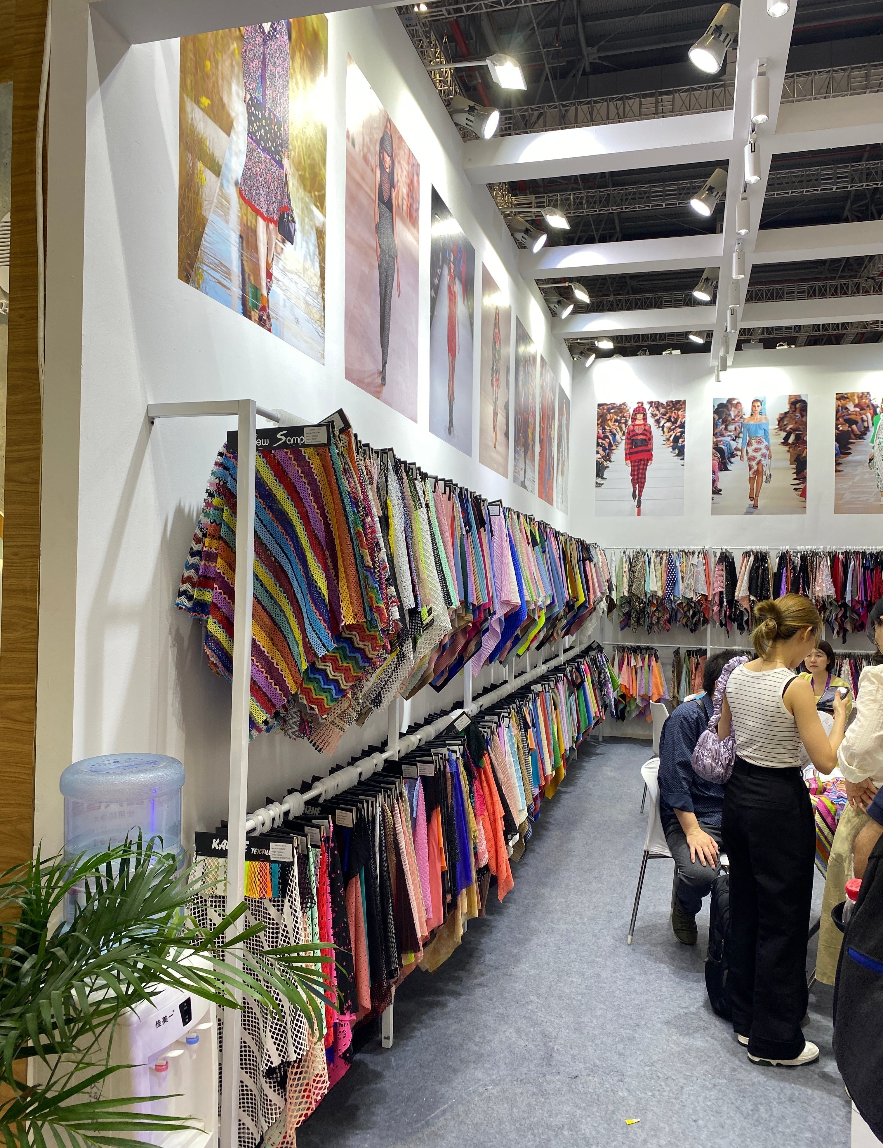 Ladies looking through a display of certified fabrics.