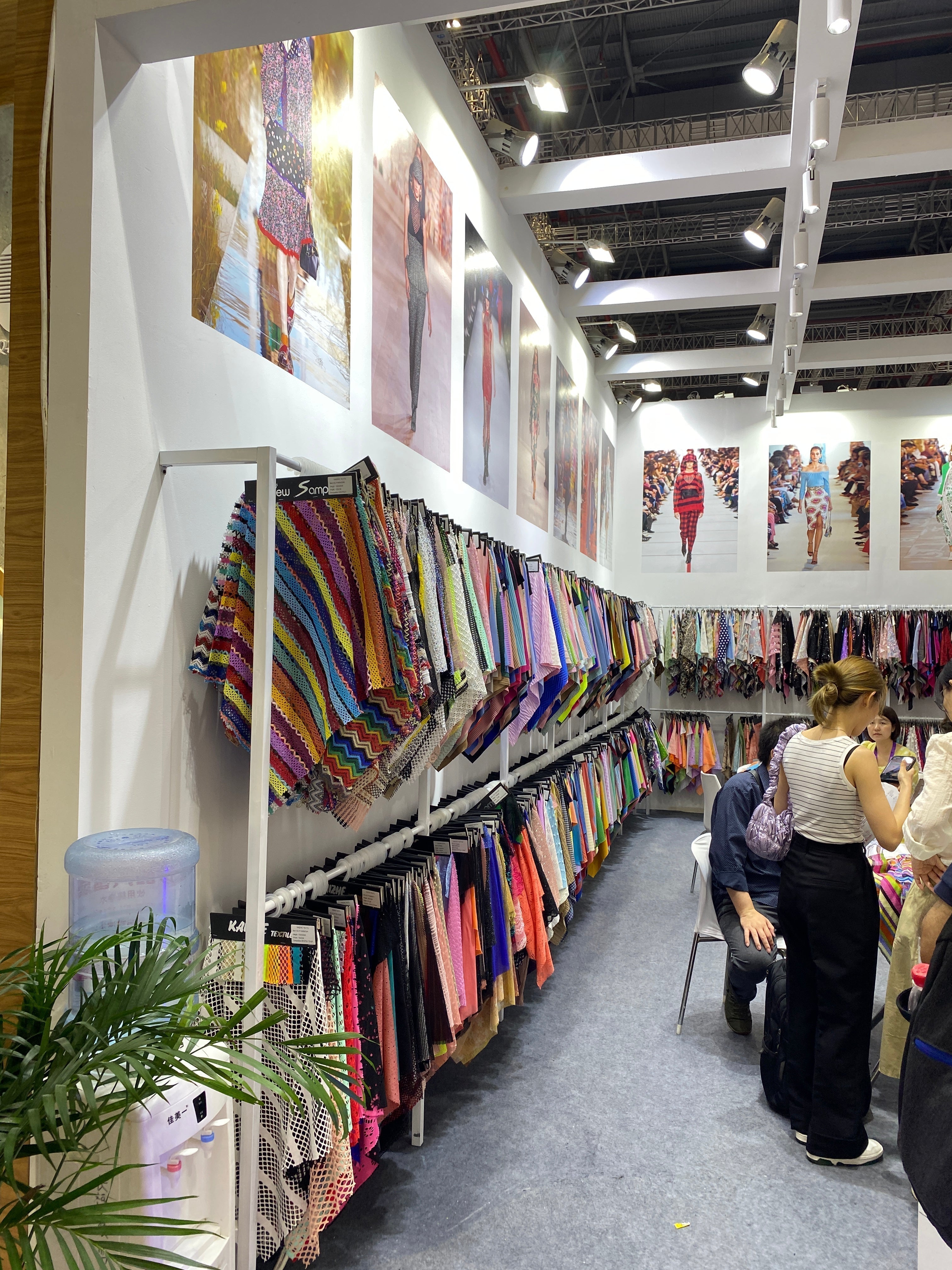 Ladies looking through a display of certified fabrics.