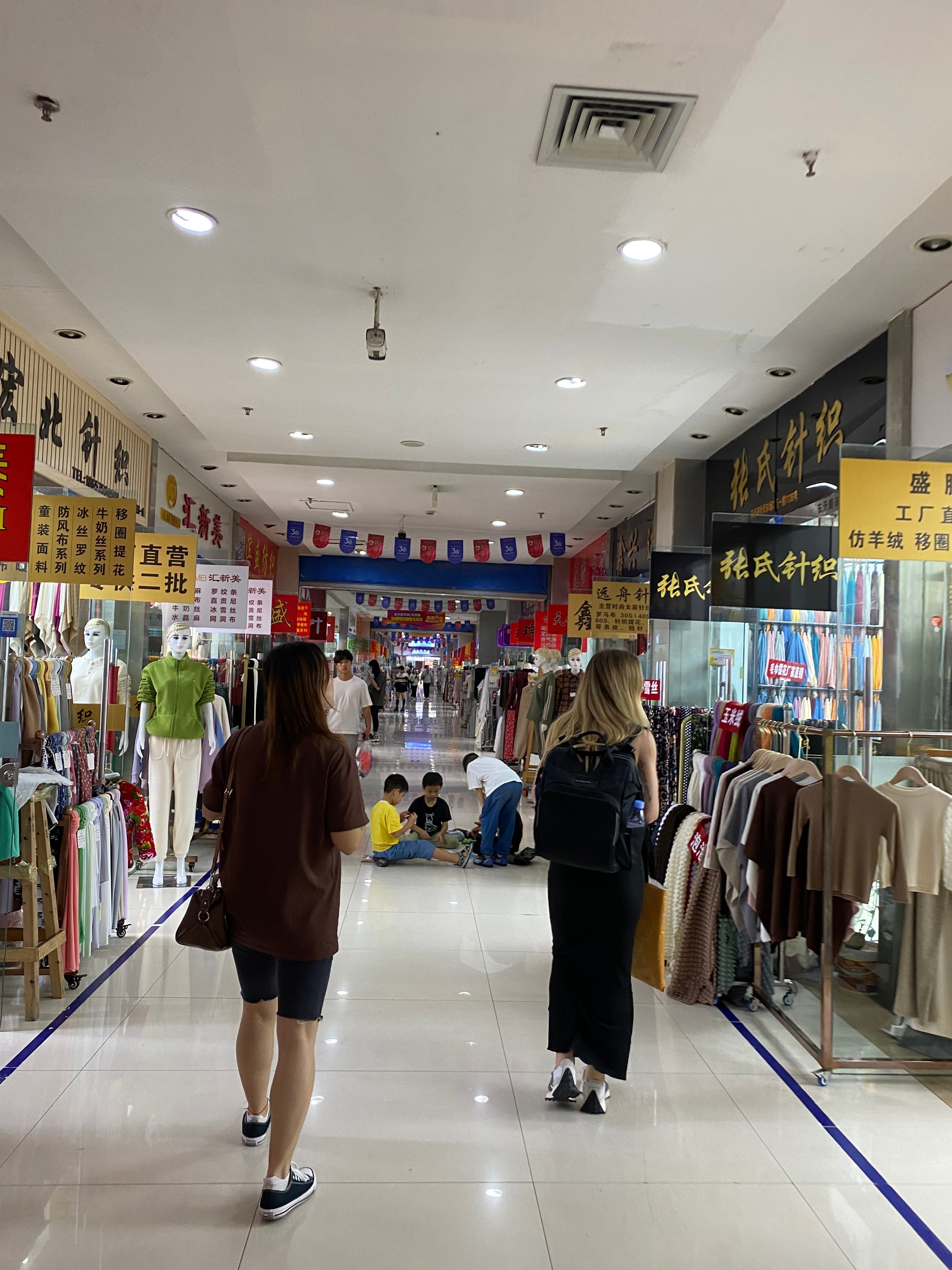 Two women shopping for fabric inside a mall in China.