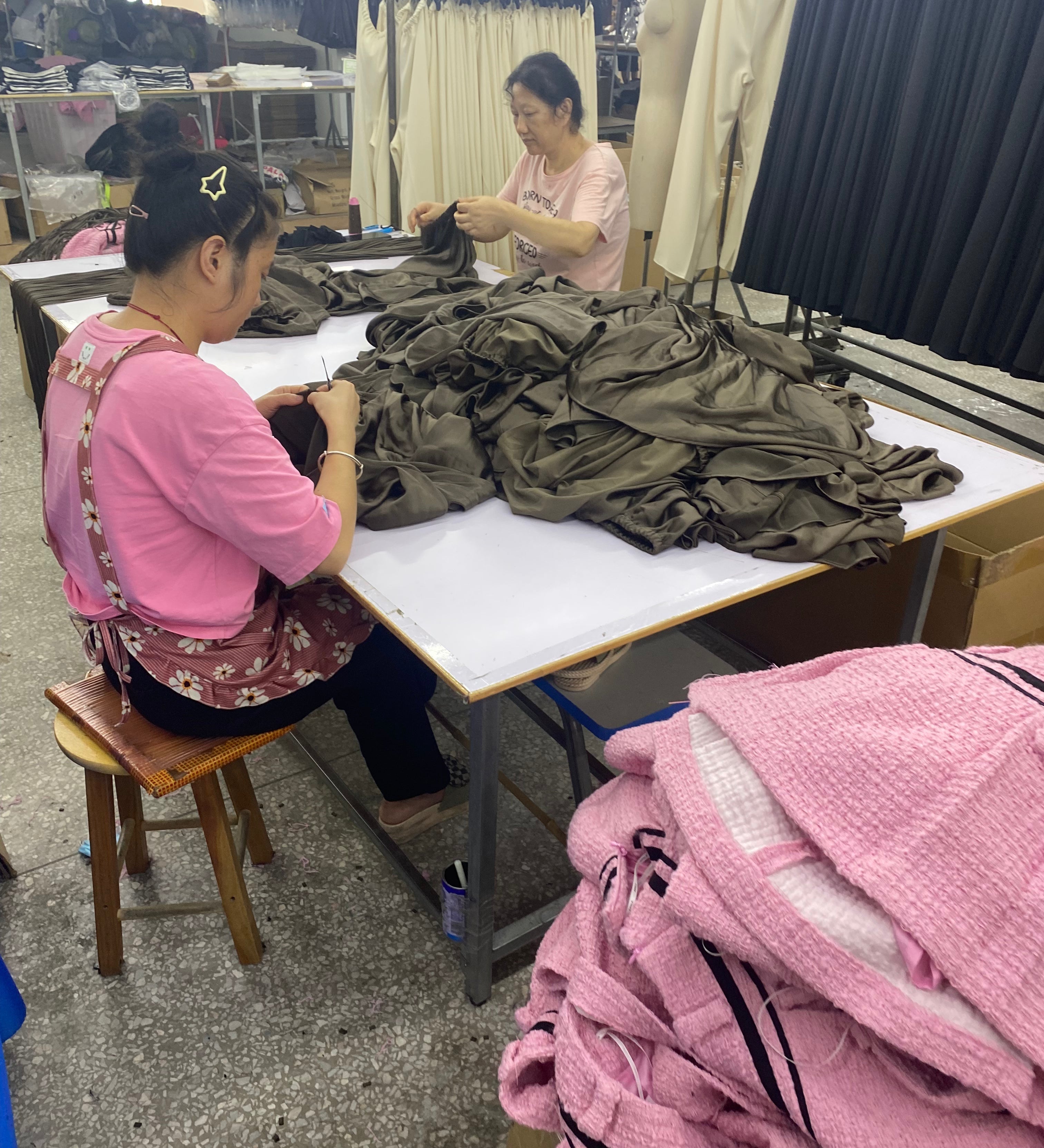 Two garment factory workers sewing clothes that were ordered at minimum order quantity.