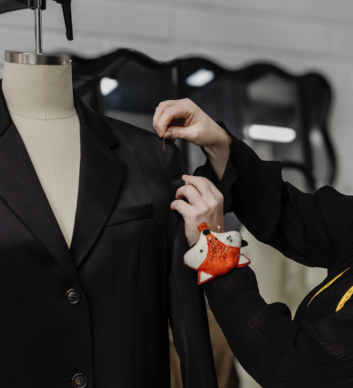 Fashion Designer conducting a sizing review and fitting of a sample garment on a dress form.