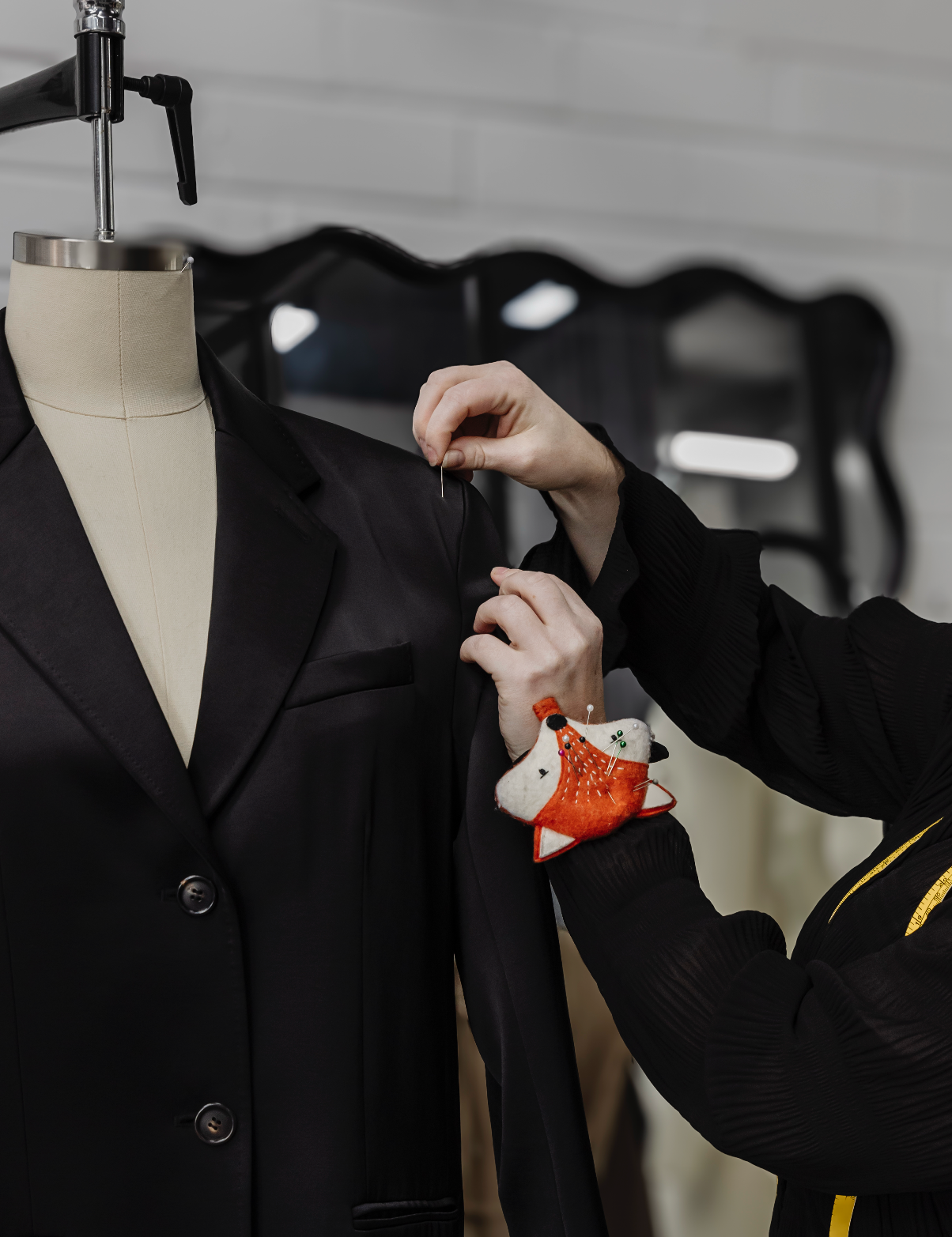 Fashion Designer conducting a sizing review and fitting of a sample garment on a dress form.