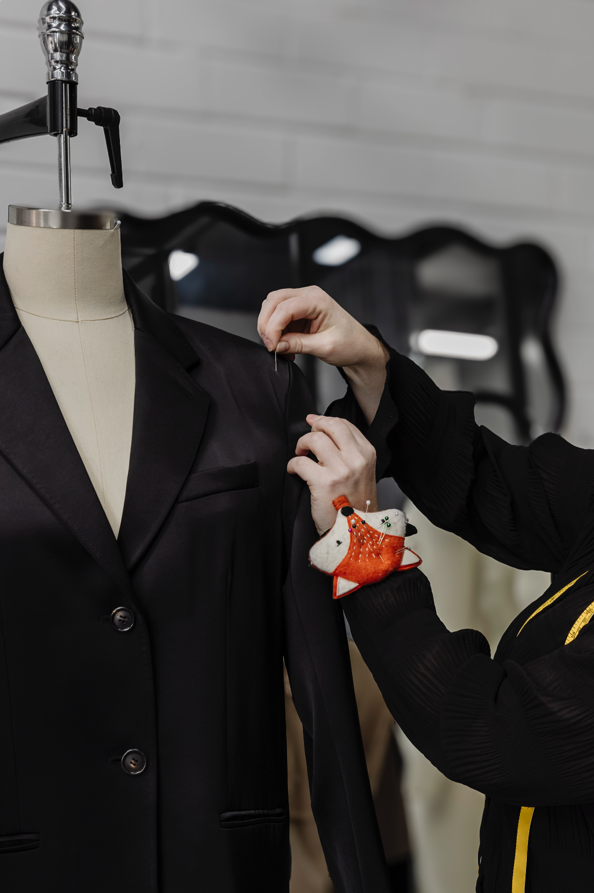 Fashion Designer conducting a sizing review and fitting of a sample garment on a dress form.