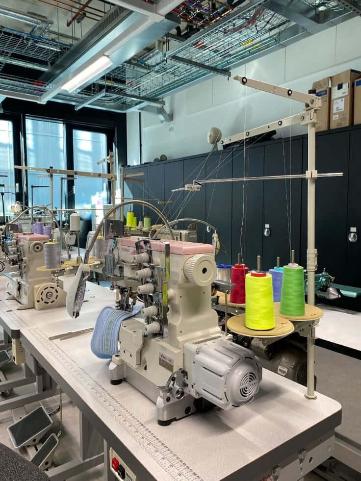 Industrial sewing machines and colourful thread in a garment factory – red flags when choosing a clothing manufacturer